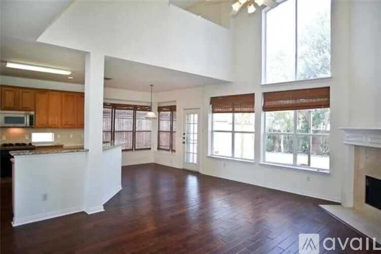 A spacious living room with wood flooring and large windows.
