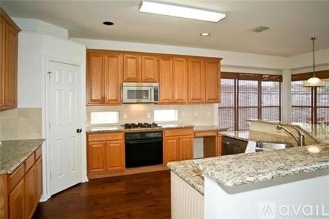 A kitchen with wooden cabinets and granite countertops.