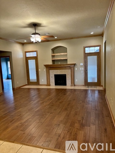 A spacious living room with hardwood floors and a fireplace.