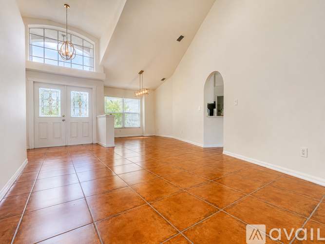 A spacious room with a tiled floor and a large window.