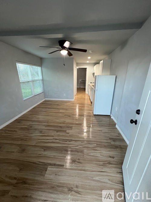 A long hallway with a fan and light on the ceiling.
