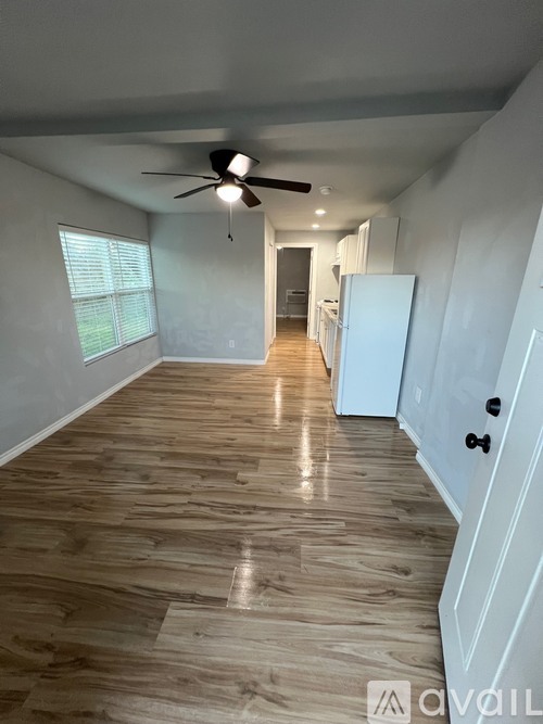 A long hallway with a fan and light on the ceiling.