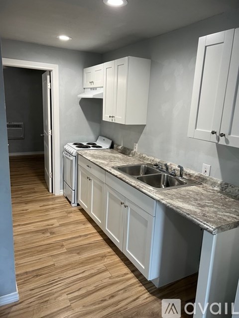 A kitchen with white cabinets and a marble countertop.