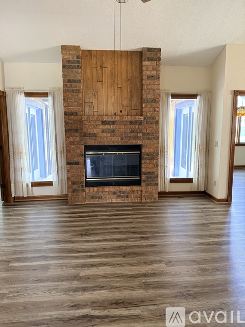 A living room with a fireplace and wooden floors.