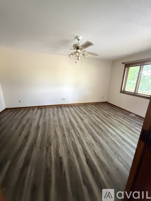A room with wooden flooring and a ceiling fan.
