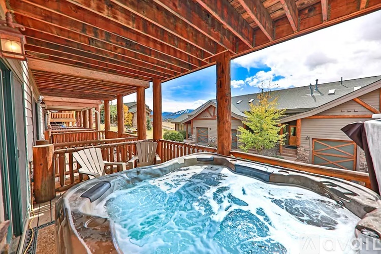 A hot tub is in the middle of a wooden deck.