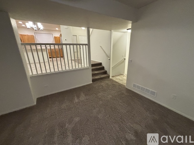 A spacious room with a staircase leading to the upper floor.
