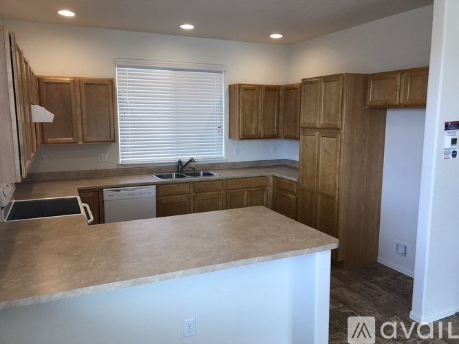 A kitchen with wooden cabinets and a marble countertop.