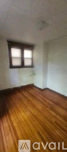 A room with wooden flooring and a window.
