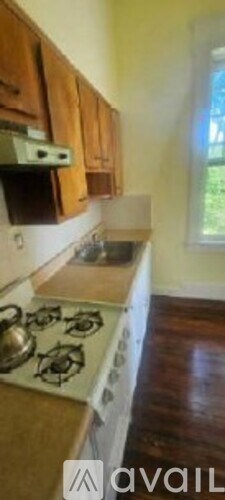 A kitchen with wooden cabinets and a white stove top.