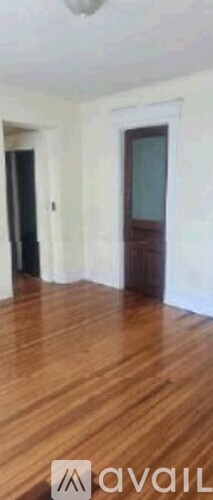 A room with wooden flooring and a door.