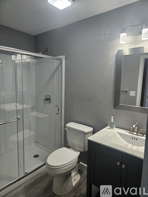 A bathroom with a toilet, sink, and shower.