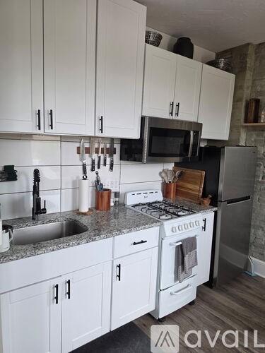 A kitchen with white cabinets and a granite countertop.