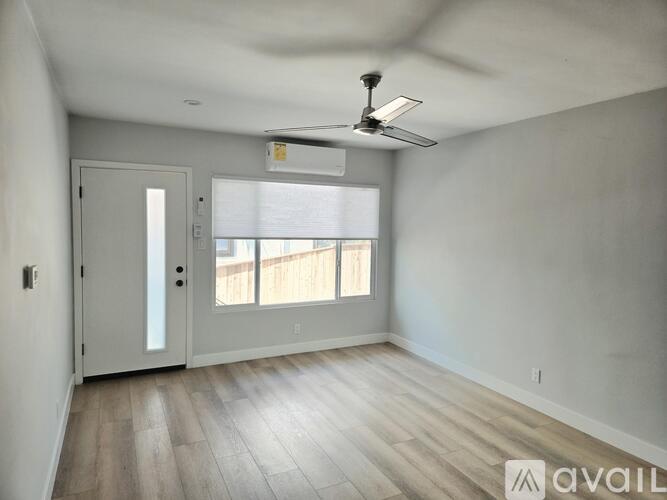 A room with a ceiling fan and wooden flooring.