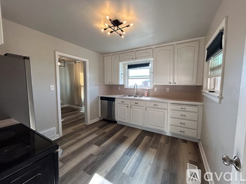 A kitchen with white cabinets and a black counter top.