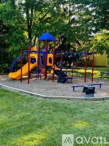 A playground with a yellow slide and a blue canopy.