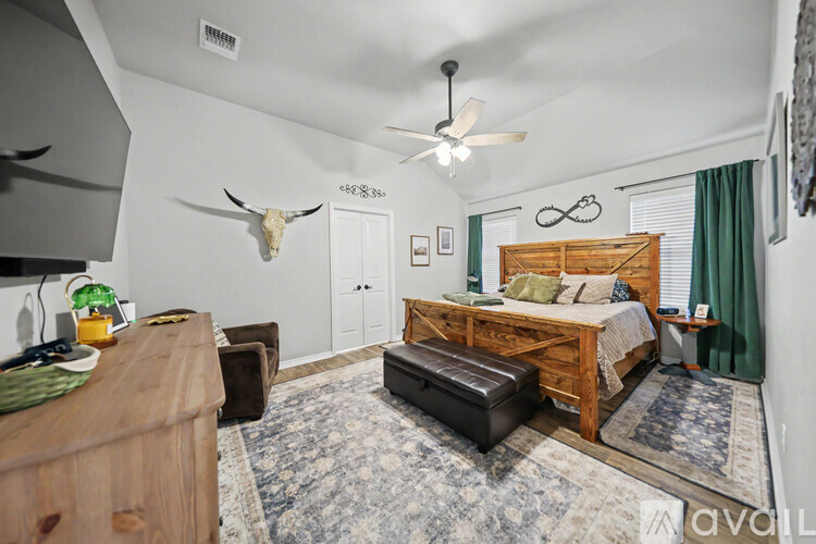 A bedroom with a bed, a bench, and a rug.