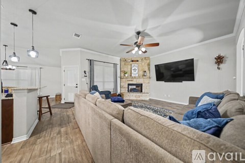 A living room with a beige couch and a fireplace.