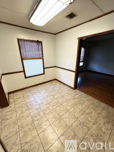 A room with a window and tiled floor.