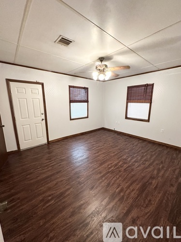 A room with wooden flooring and a ceiling fan.