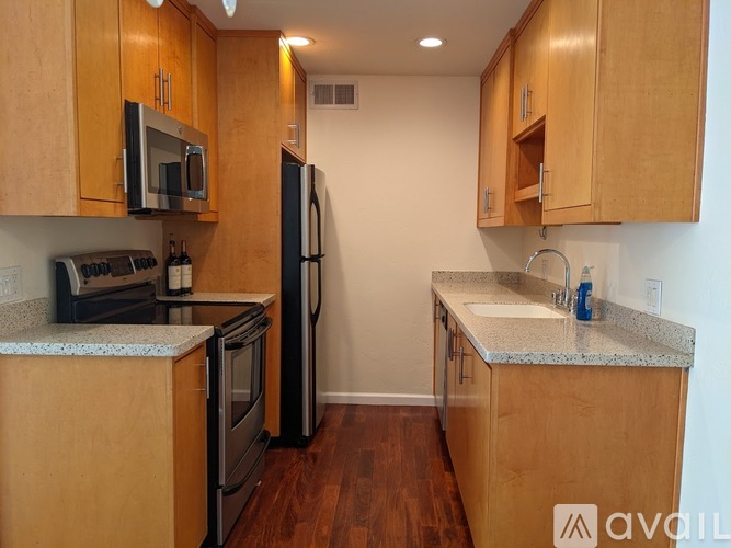 A kitchen with wooden cabinets and a black refrigerator.