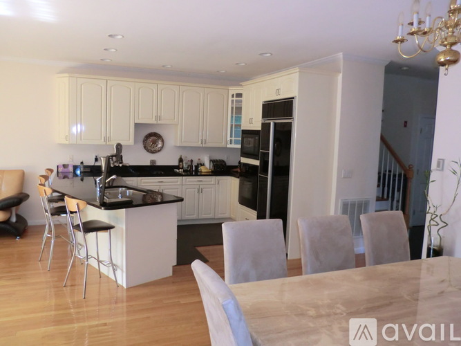 A kitchen with a table and chairs in front of it.