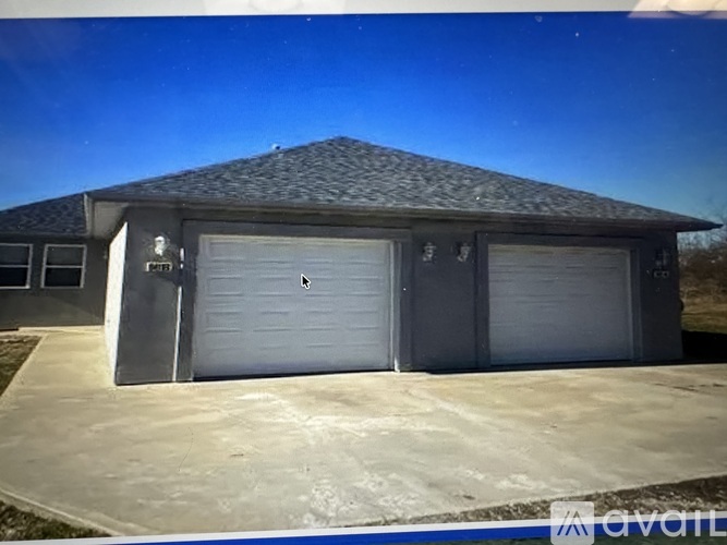 A two-car garage with a grey roof and white doors.