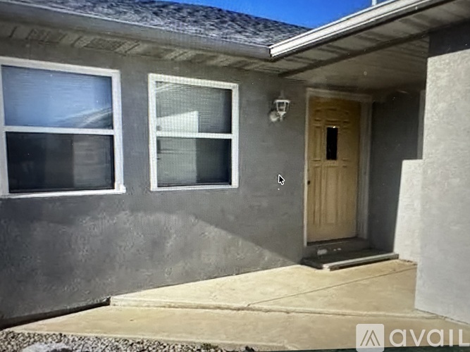 A house with a grey wall and a wooden door.