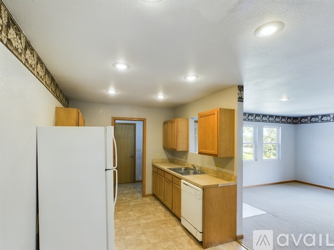 A kitchen with wooden cabinets and a white refrigerator.