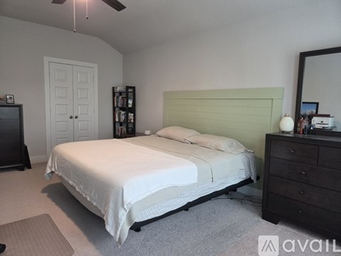 A bedroom with a white bed and a green headboard.