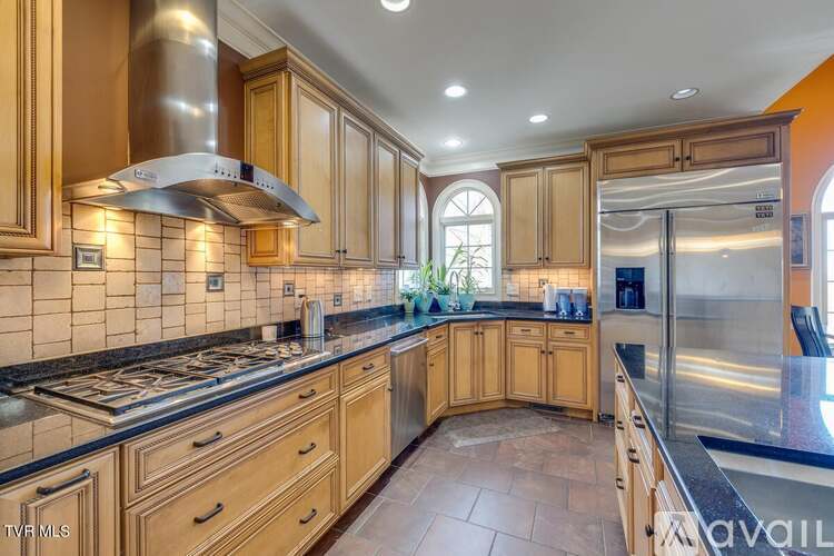 A kitchen with wooden cabinets and a stainless steel range hood.