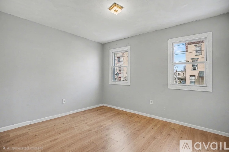 A room with a wooden floor and two windows with pictures on them.
