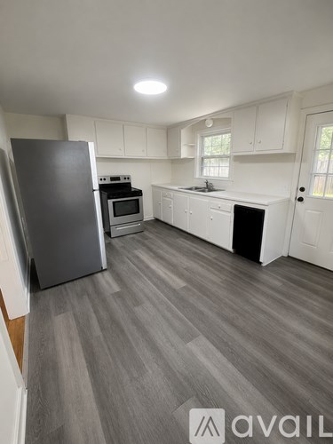 A kitchen with a refrigerator, oven, and microwave.