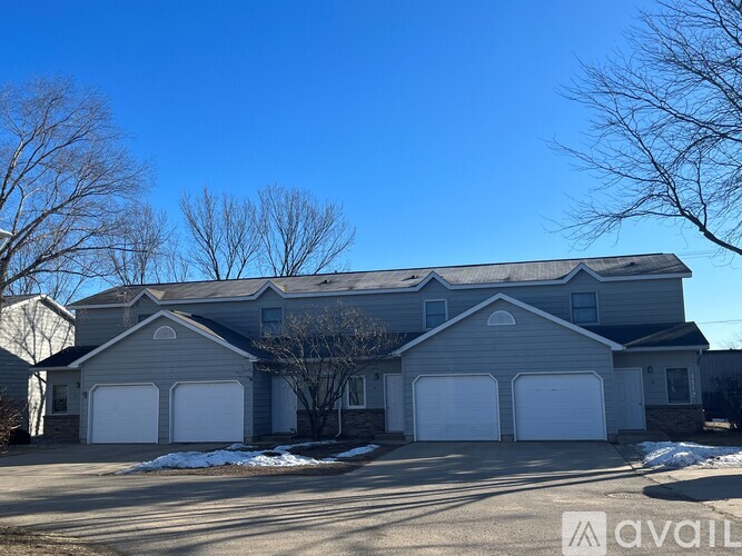 A house with a grey roof and white garage doors is for sale.