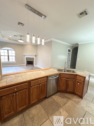 A kitchen with wooden cabinets and a marble countertop.