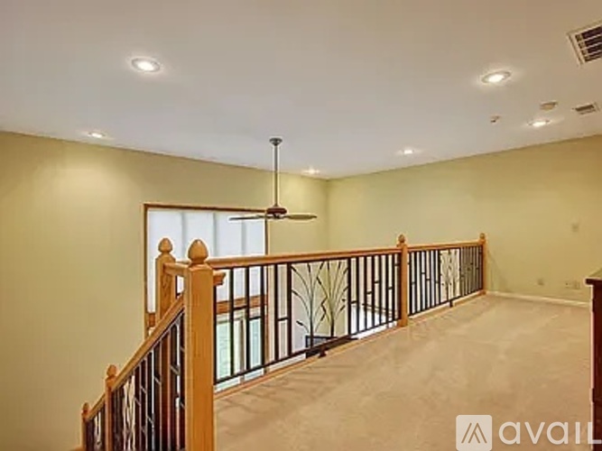 A spacious room with a balcony and a ceiling fan.