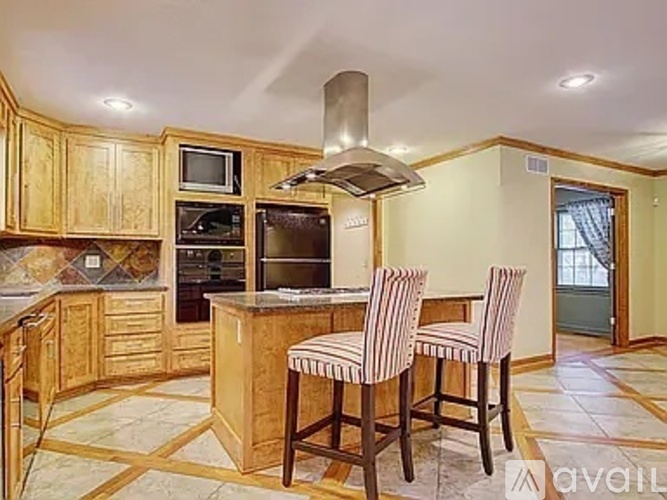 A kitchen with wooden cabinets and a marble floor.