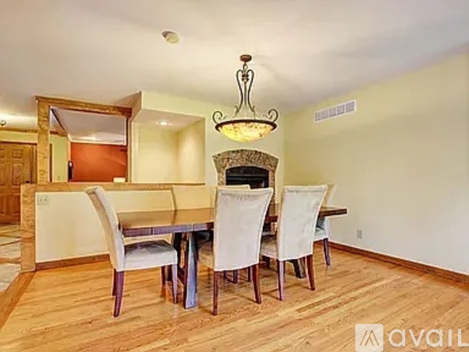 A dining room with a wooden table and chairs.