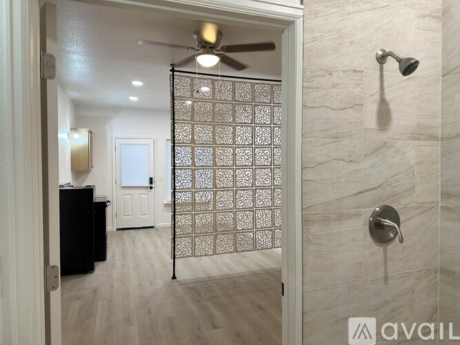 A bathroom with a shower and a ceiling fan.