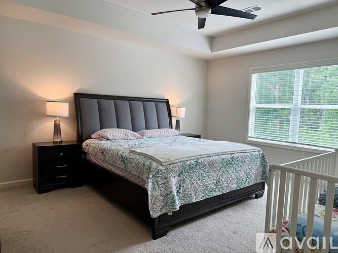 A bedroom with a large bed and a ceiling fan.