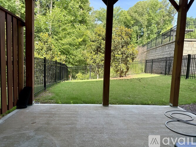 A patio with a black fence and green grass in the background.