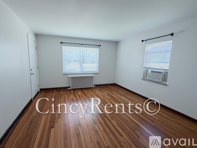 A room with wooden floors and two windows.
