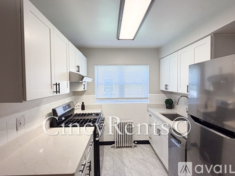 A kitchen with white cabinets and a stainless steel refrigerator.