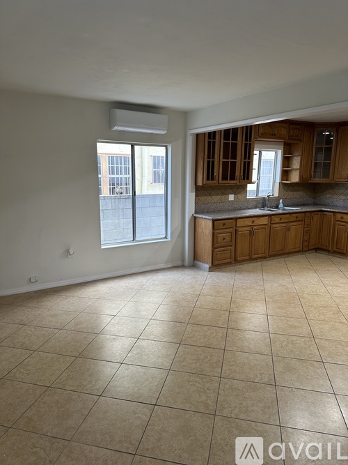 A kitchen with wooden cabinets and a tiled floor.