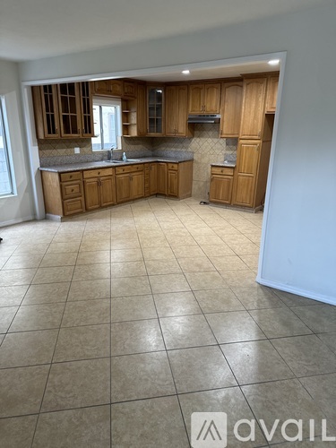 A kitchen with wooden cabinets and a tile floor.