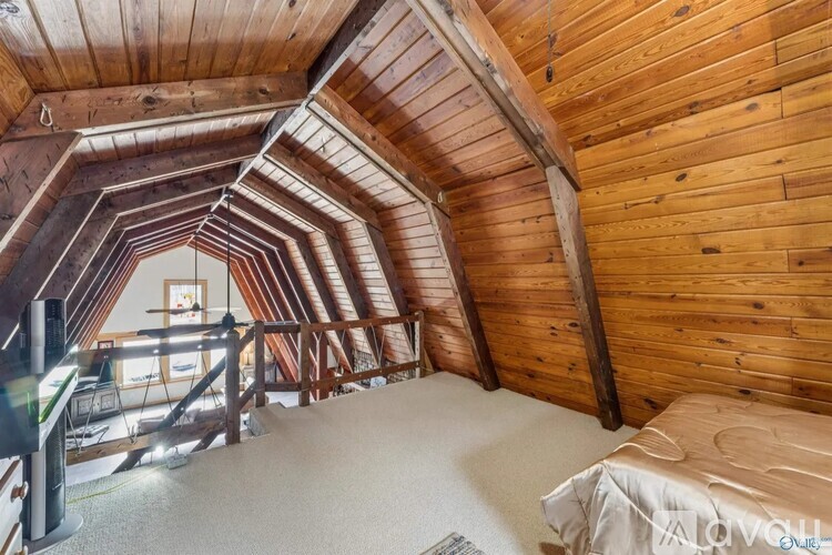 A bedroom with wooden walls and a bed in the corner.