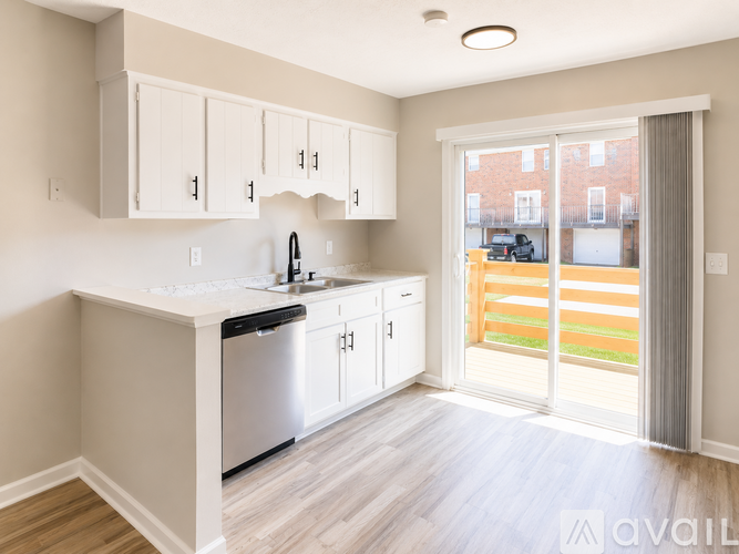 A kitchen with white cabinets and a stainless steel dishwasher.