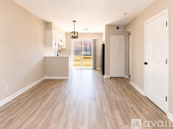 A spacious room with wooden floors and white walls.
