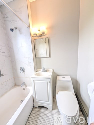 A white bathroom with a tub, sink, and toilet.