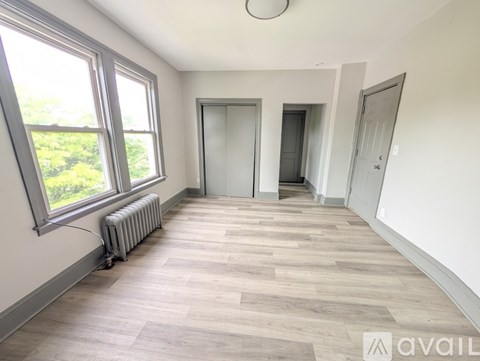 A room with a window, a radiator, and two doors.